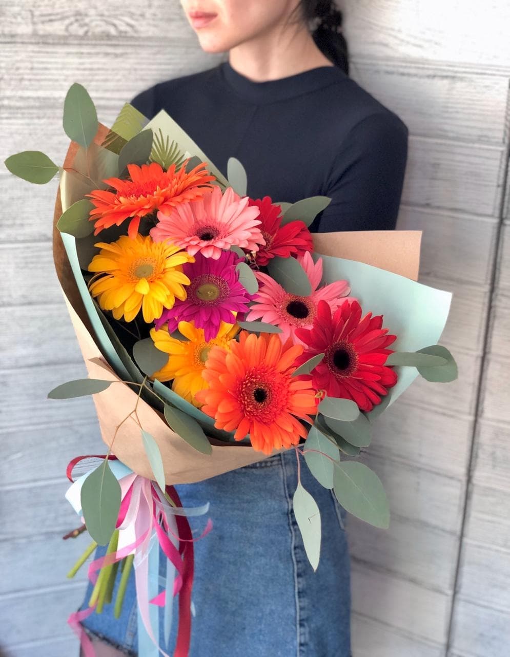 Весенний букет из 9 гербер в крафте с зеленью